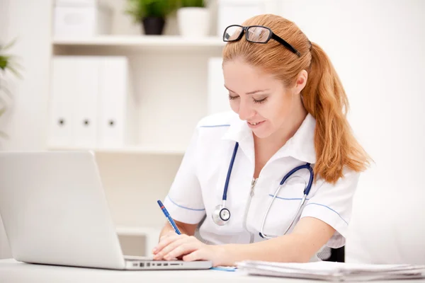 Portrait of a smiling physician working in her office Stock Image