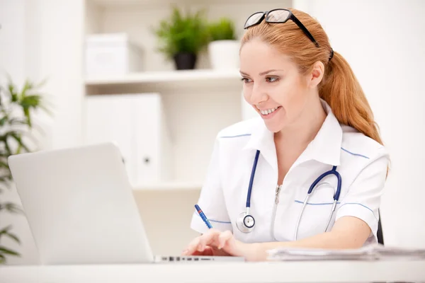 Portrait of a smiling physician working in her office Royalty Free Stock Images