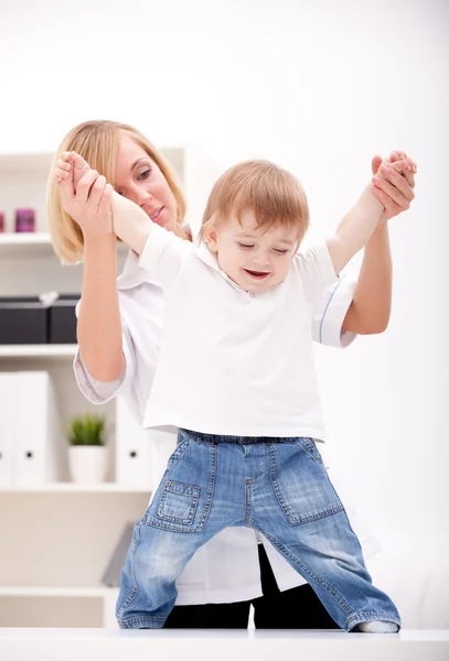 Arzt hält ein Baby an den Händen — Stockfoto