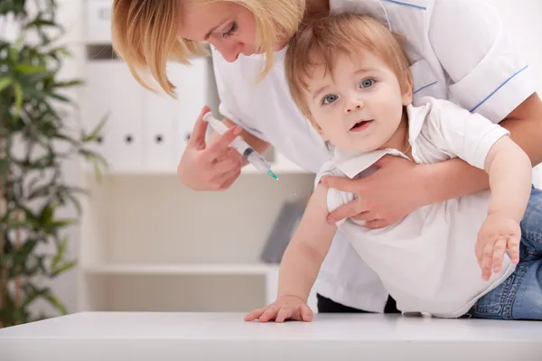 Врач вводит ребенку инъекцию в руку — стоковое фото