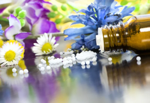 Homeopathische bolletjes met bloemen Rechtenvrije Stockafbeeldingen