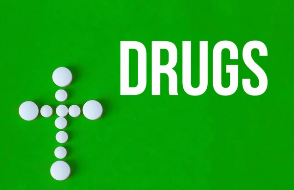 White Pills Making Cross Green Background Word Drugs Written — Foto de Stock