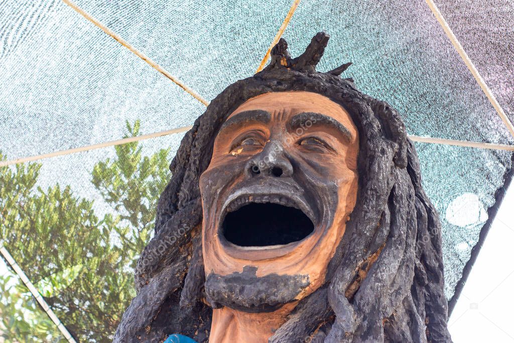 statue of bob marley with dreadlocks and burned