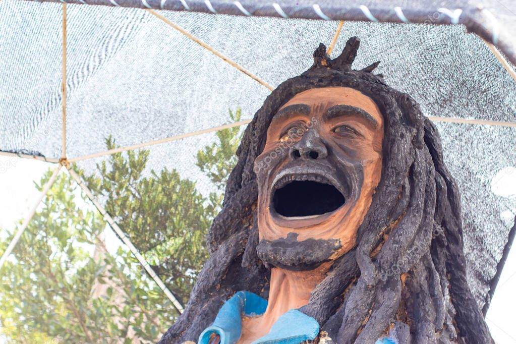 statue of a man with long dreadlocks and an open mouth