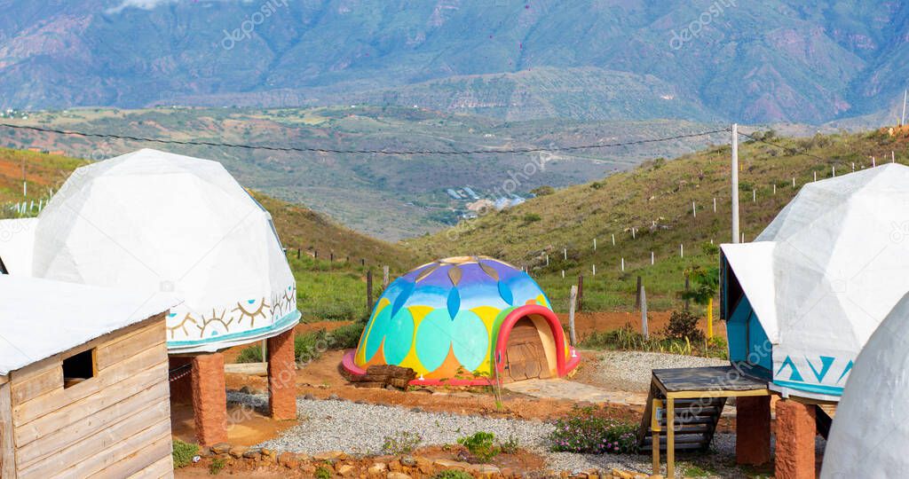 brightly colored dome in the middle of the green mountain