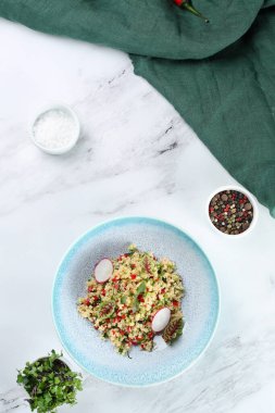 Sebzeli bulgur kırmızı biber ve turp açık mermer arka planda