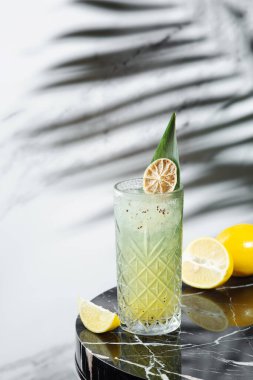 Kivi kokteyli ile turunçgil ya da mermer masanın yanında dilimlenmiş limonata. Alkollü ya da alkolsüz içki arka planda Hrad Gölgesi.