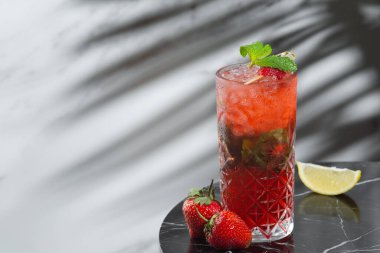 Mermer masanın yanında çilekli mojito. Taze kokteyl ya da limonata. Bar konsepti. arkaplandaki sert gölge.