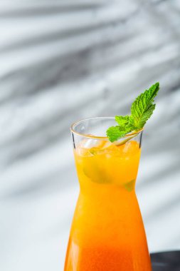 Şeftalili limonata sürahisi. Yaz soğuk içecekleri: buzlu ev yapımı şeftali çayı, ve hafif arka planda nane şekeri.