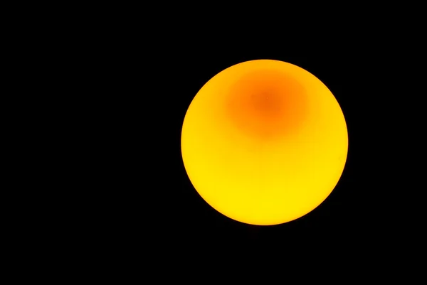 Esfera amarela sobre um fundo preto — Fotografia de Stock