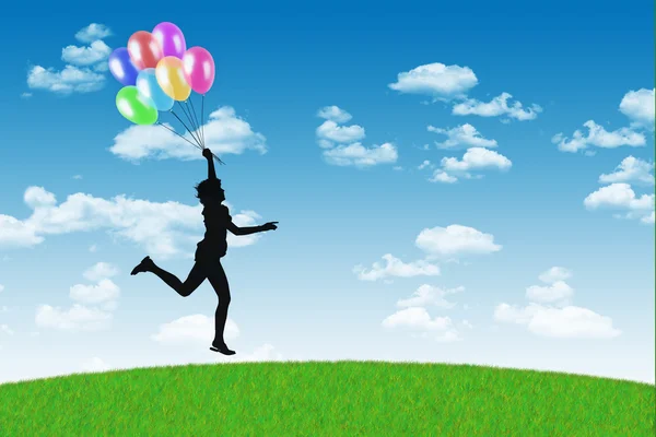 Happy woman running with balloons on a blue sky background — Stock Photo, Image