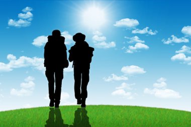 güneşe karşı bir tepenin üstüne yürüyen backpackers bir kaç