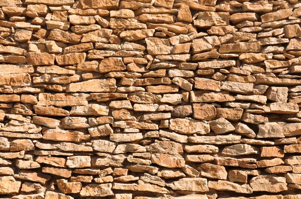 Old wall made of big and little yellow stones — Stock Photo, Image