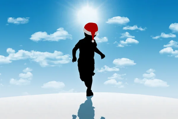 Маленький мальчик бежит в красной шляпе на зимнем фоне — стоковое фото