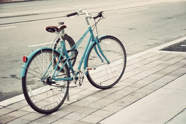 Kvinnors cykeln parkerad på gatan — Stockfoto