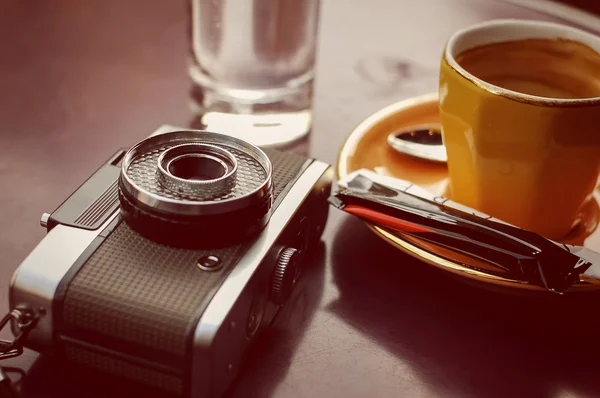 Empty cup of coffee and retro camera — Stock Photo, Image