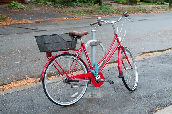 Kvinnors cykeln parkerad på gatan — Stockfoto