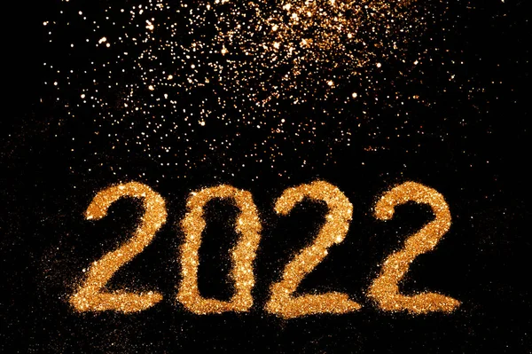 Numeri festivi 2022 realizzati in glitter dorato su sfondo nero. Natale, inverno, capodanno. Layout piatto, vista dall'alto, spazio di copia — Foto Stock
