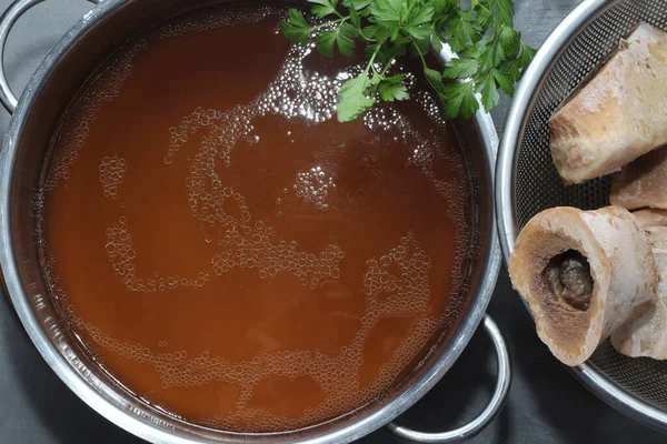 鍋に自家製牛骨スープ 骨にコラーゲンが含まれてる 接近中だ 上からの眺め ストック写真