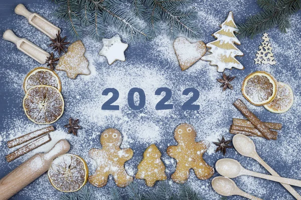 ハッピーニューイヤー2022小麦粉で書かれています 調理のための成分とクリスマスベーカリーの背景 彼らは小枝 ジンジャーブレッド 小さな男を食べた 小麦粉 スパイス おもちゃのトップビュー ストックフォト