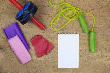 Lastik bant, ip atlama, kalemle defter. Yeni yıl sporu. Başarının hedefine doğru koş. Spor ve kilo verme kavramı. Düz yatıyordu.