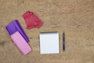 Lastik bantlar, genişletici, defter mantar arka planda yatıyor. Başarının hedefine doğru koş. Spor konsepti.