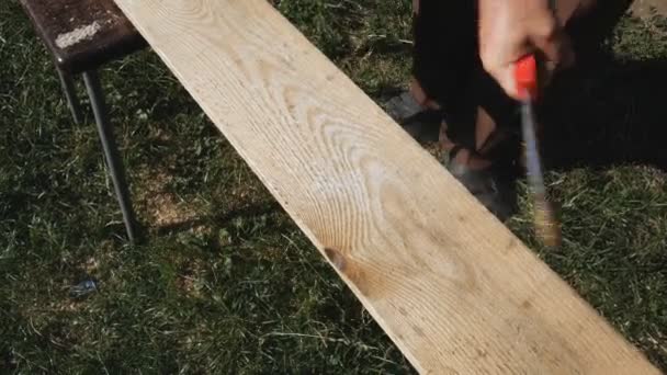 Preparation of wooden boards for processing. Cleaning the surface of the board from rough burrs with an iron brush — Stock Video