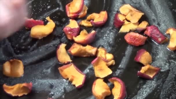 Öntsön szárított almadarabokat egy sütőedénybe. Olajozott serpenyő — Stock videók