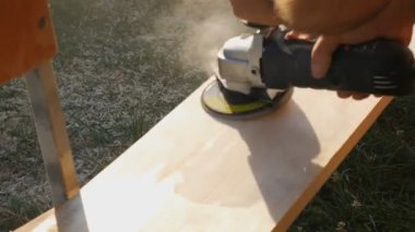 Bir marangoz öğütücüyle ahşap işliyor. Bir işçi elektrikli bir aletle ahşap bir yüzeyi öğütüp parlatır.