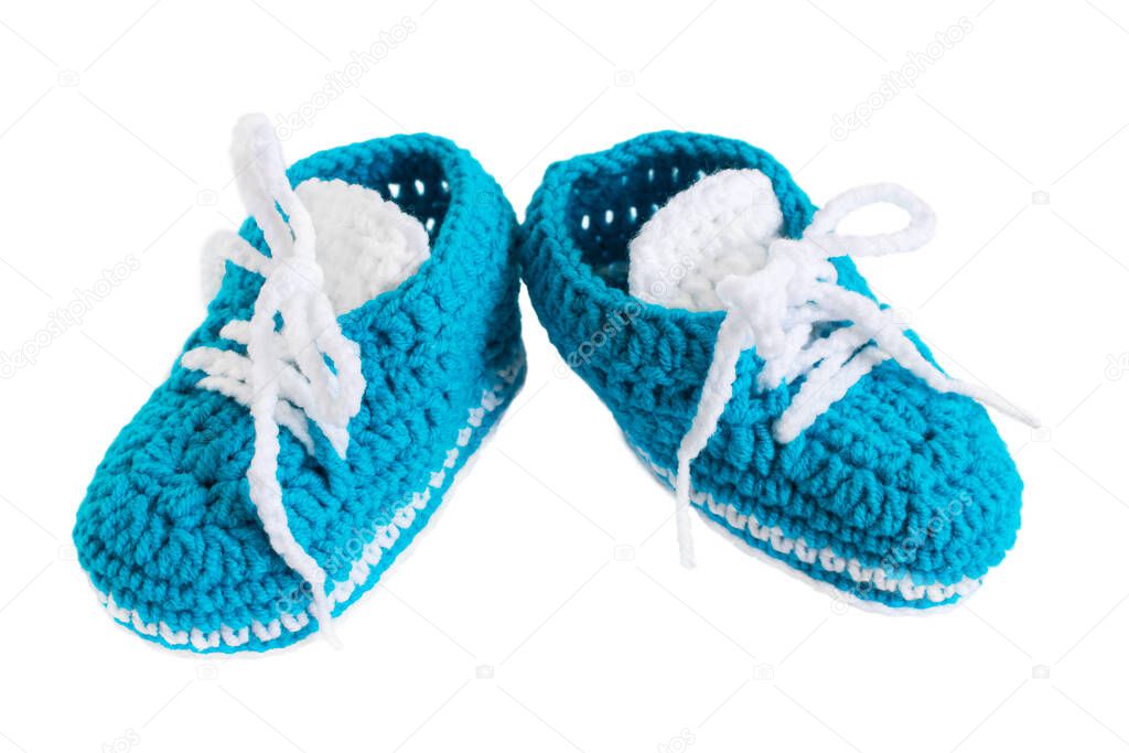 Knitted booties isolated. Blue handmade small shoes for a newborn boy on a white background. The concept of motherhood, the appearance of the firstborn. Design of children's cards, packages, websites