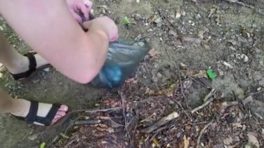 Plastik çöp topla. Genç bir adam şişeleri, bardakları, atıkları bir çöp torbasına koyar. Çevre koruma kavramı, doğaya karşı dikkatli tavır, atıksız üretim. Çevre gönüllüsü