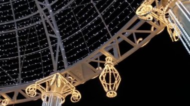 Noel sokak dekorasyonları. Gece kenti gece lambalarının hafif süslemeleri. Noel konsepti, yeni yıl, tatiller, sihir. Balkonun dekoratif tasarımı yakın planda parlıyor.
