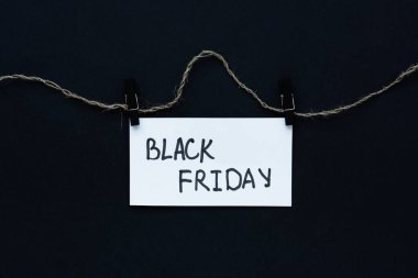 Kara Cuma mesajı. İpin üzerinde siyah arka plan beyaz el işareti var. Kavramsal iş minimalizmi. Satışlar, promosyonlar, indirimler, online alımlar. Yatay Pankart.