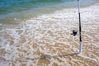 Plastik bir borunun içinde balığın ısırmasını bekleyen bir olta kamışı.