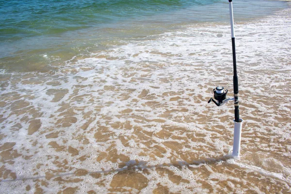 Plastik bir borunun içinde balığın ısırmasını bekleyen bir olta kamışı.