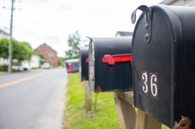 row of suban streetside wood and metal mailboxes