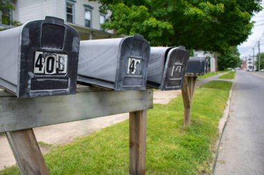 cluster line of street-side residential mailboxes in perspective