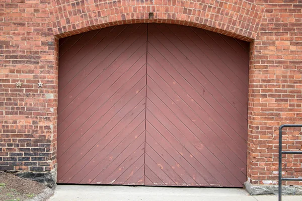 red painted wood double door entrance of the brick structure