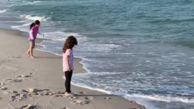Deniz dalgalarıyla oynayan iki genç kız.