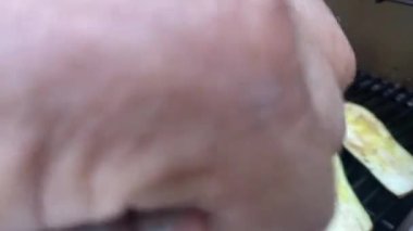 İki uçlu uzun çatallı bir adam tavuk budu ve yeşil kabak pişiriyor.