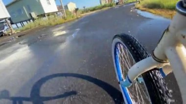 Su dolu yollarda bisiklete binen bir adam yüksek gelgite neden olur.