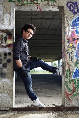 Genç Asyalı çocuk posingfor şık fotoğraf bina kalıntıları içinde