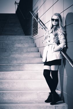 Genç sarışın güzel Bayan güzellik çekimleri için poz şehir merdivenlerde