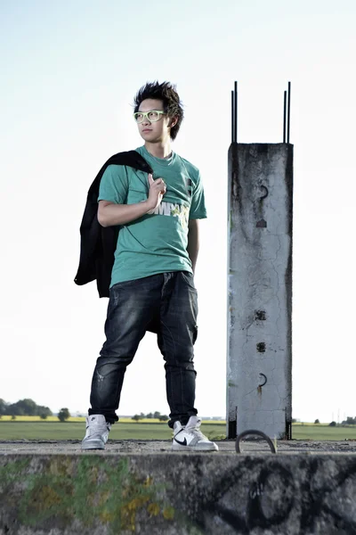 Young Asian boy posingfor stylish photos in ruins of building — Stock Photo, Image