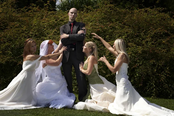 Brides and bridegroom in summer garden — Stock Photo, Image