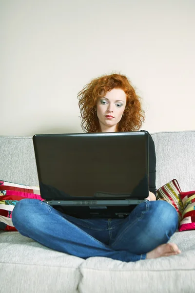 Senhora em casa com notebook trabalhando e navegando na internet — Fotografia de Stock