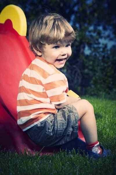 Мальчик играет рядом с домом в саду — стоковое фото