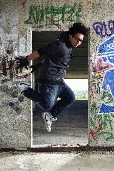 Jeune garçon asiatique posant pour des photos élégantes dans les ruines du bâtiment — Photo