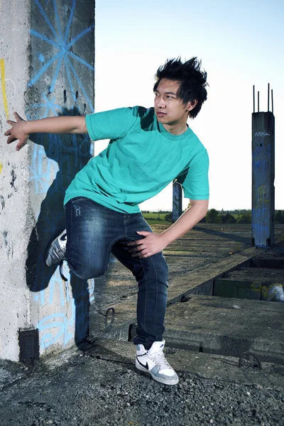 Jonge Aziatische jongen posingfor stijlvolle foto's in ruïnes van gebouw — Stockfoto