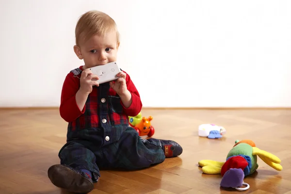 Jongen speelt binnen op houten vloer — Stockfoto